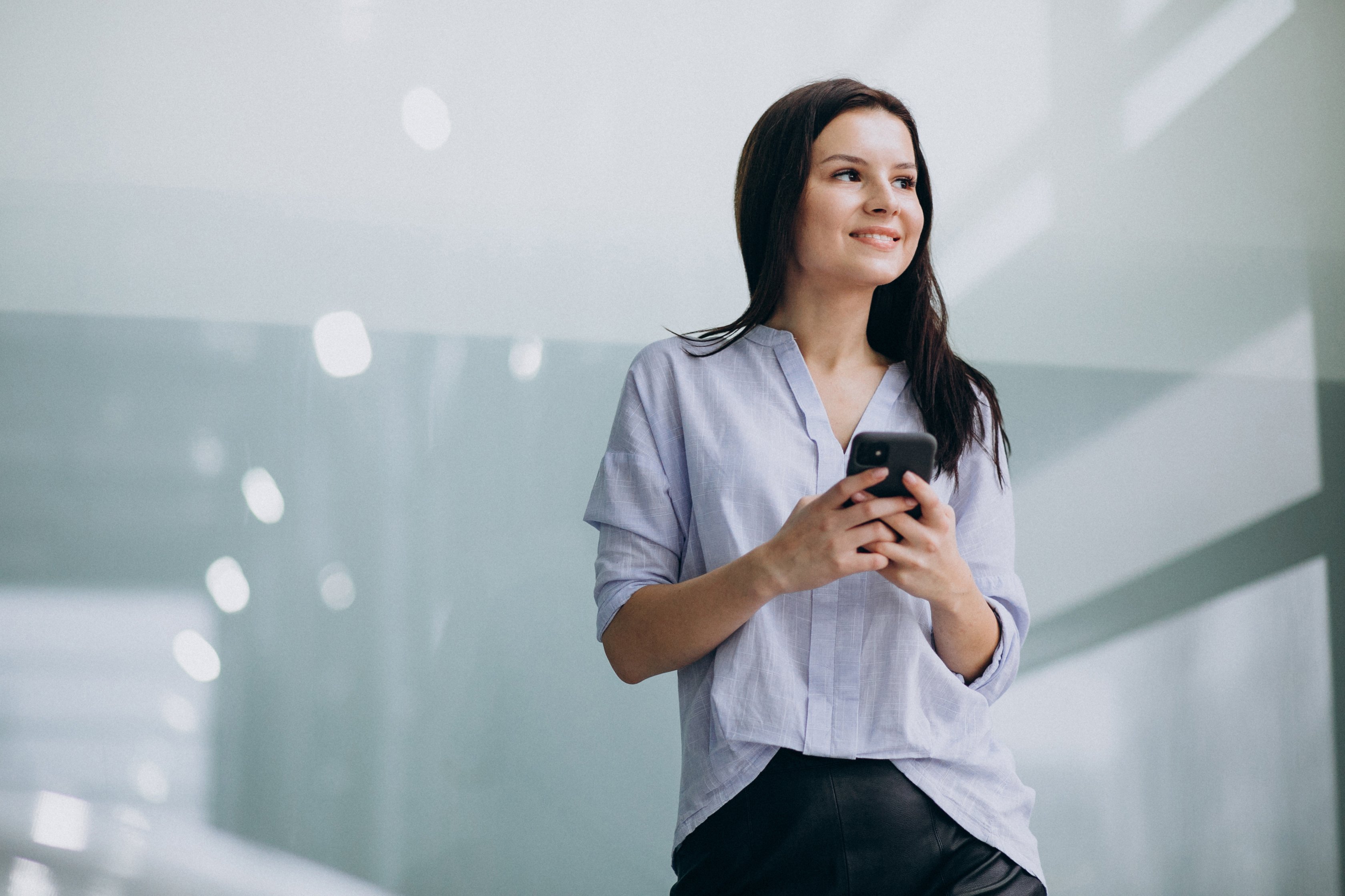 young-business-woman-using-phone-at-the-office